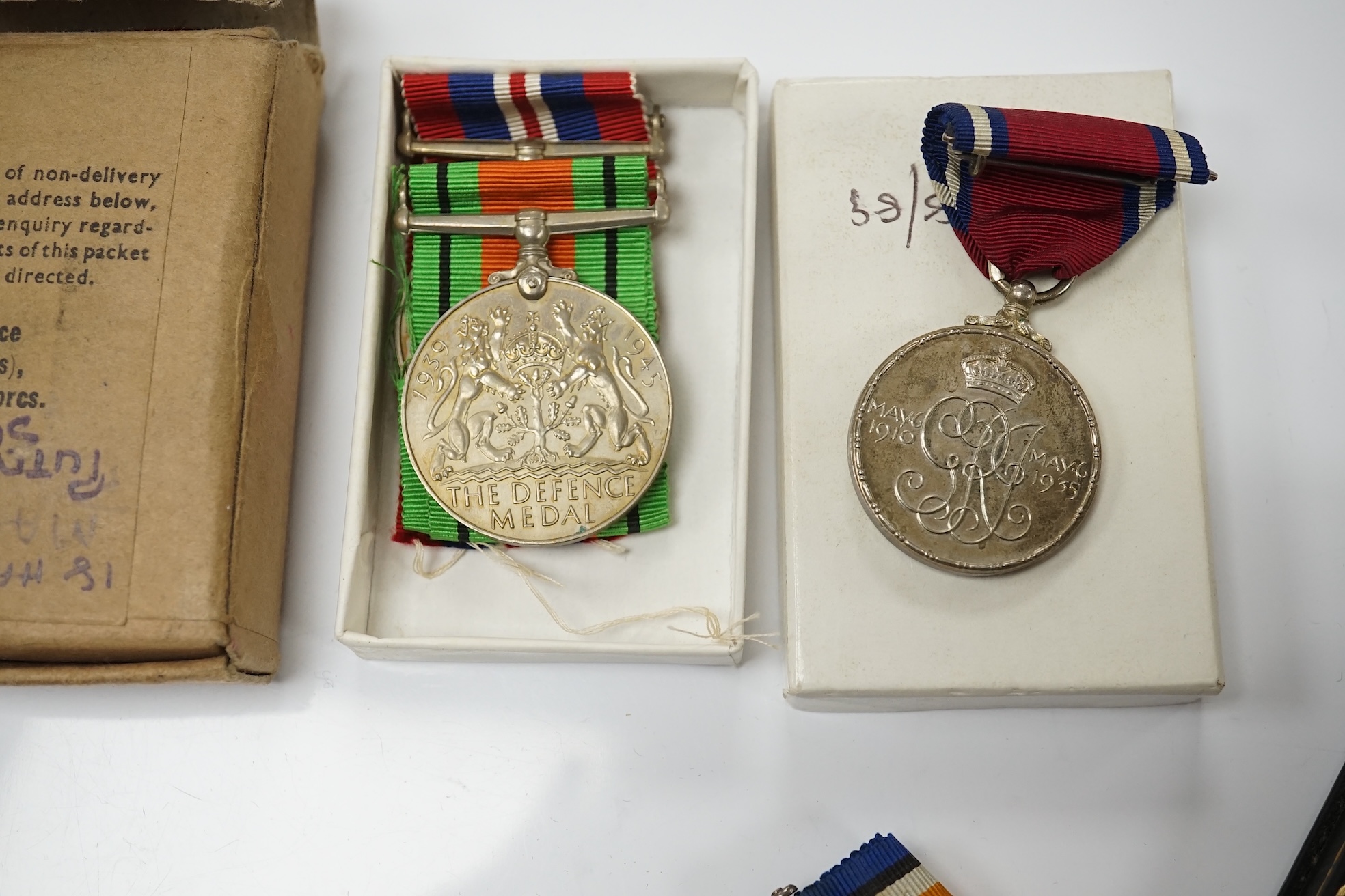 A collection of military interest medals and cloth badges to include a 1914-1918 medal awarded to Lieut. W. C. Griffith and an unnamed 1910-1935 medal. Condition - varies